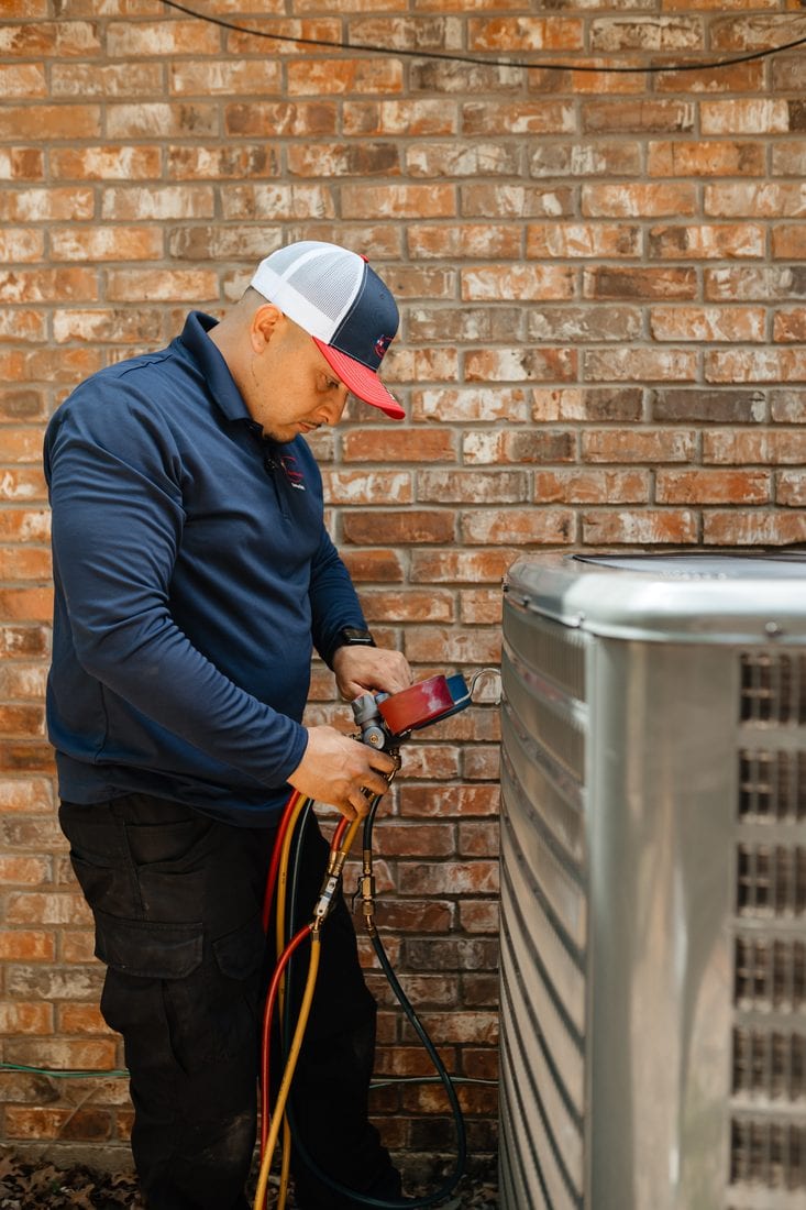 A Lexany's technician servicing an outdoor AC condenser at a Forney, TX home